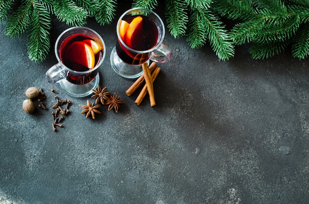 Natal mulled vinho tinto com especiarias no fundo escuro de concreto