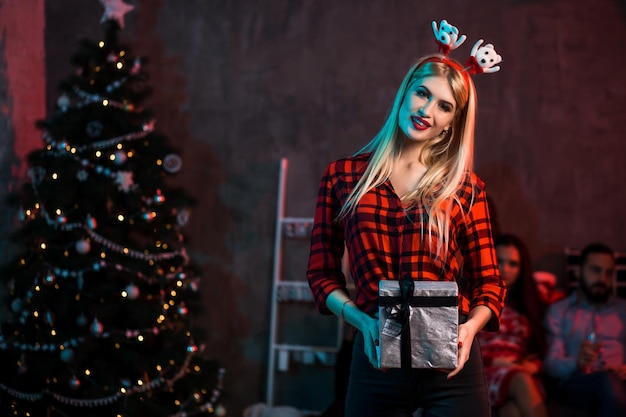 Natal, natal, ano novo, inverno, conceito de felicidade - mulher sorridente com chapéu de ajudante de Papai Noel com caixa de presente