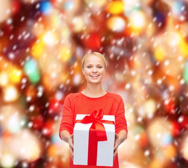 natal, natal, dia dos namorados, conceito de celebração - mulher sorridente com suéter vermelho com caixa de presente