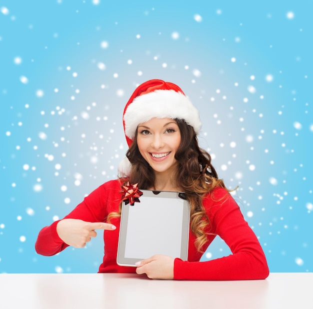 natal, natal, eletrônicos, conceito de gadget - mulher sorridente com chapéu de ajudante de Papai Noel com tela em branco do tablet pc