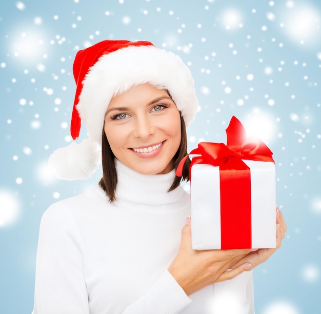 natal, natal, inverno, conceito de felicidade - mulher sorridente com chapéu de ajudante de Papai Noel com caixa de presente