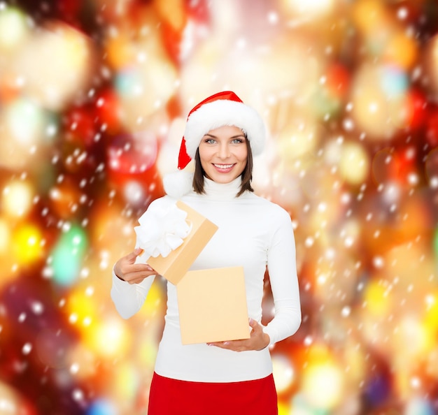 natal, natal, inverno, conceito de felicidade - mulher sorridente com chapéu de ajudante de Papai Noel com caixa de presente