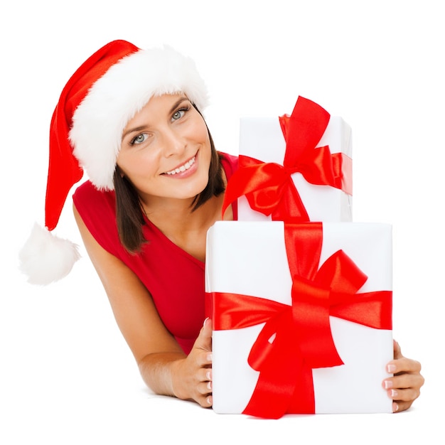 natal, natal, inverno, conceito de felicidade - mulher sorridente com chapéu de ajudante de Papai Noel com muitas caixas de presente