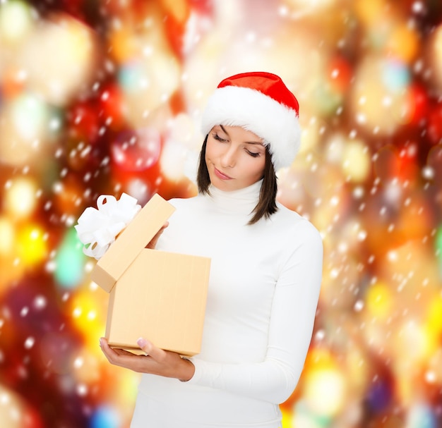 natal, natal, inverno, conceito de felicidade - mulher suspeita com chapéu de ajudante de Papai Noel com caixa de presente