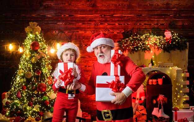 Natal papai noel e criança com presente de Natal, férias em família e conceito de infância.