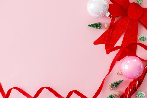 Natal rosa Moderno plano de Natal com enfeites de arco vermelho pequenas árvores e fitas em rosa