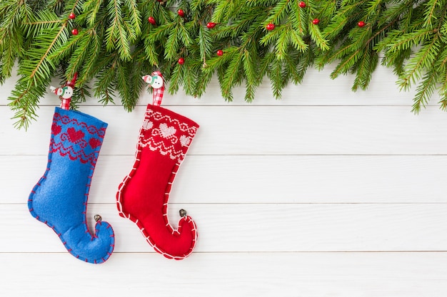 Natal. Árvore de Natal com decoração, duas meias de Natal em fundo branco placa de madeira. copyspace