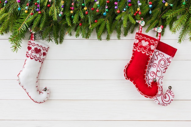 Natal. Árvore de Natal com decoração, meias de Natal coloridas sobre fundo branco de madeira com copyspace