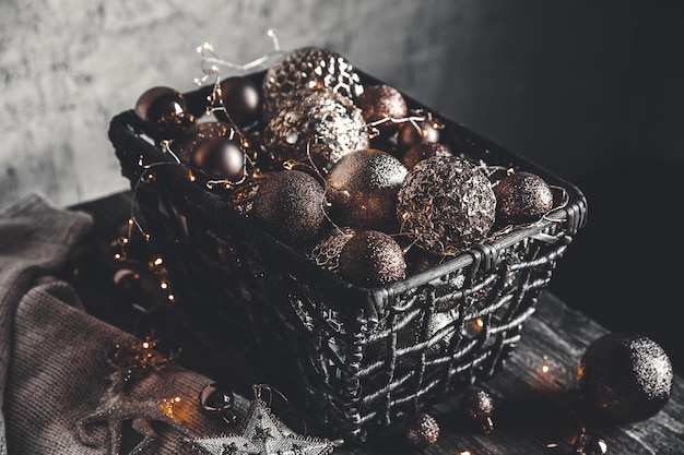 Natal vintage, brinquedos de ano novo e decoração em uma cesta na mesa de madeira marrom com guirlandas, copie o espaço