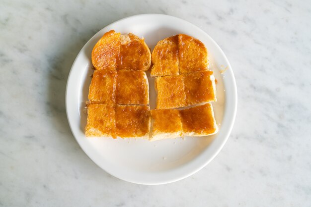 Natillas con pan tostado en la placa blanca.