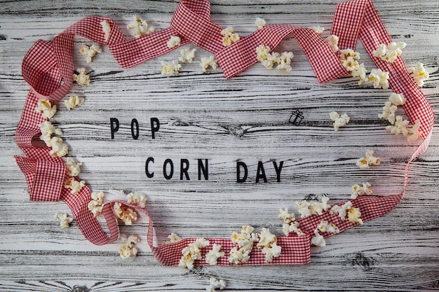 National Pop Corn Day Text im Kreis von Popcorns und rotem Band Hintergrund Draufsicht Vintage-Stil