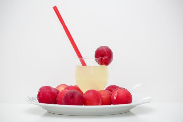 Nationaler Pflaumensaft mit Glas, das mit der Frucht am Rand verziert ist