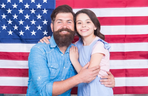 Nationaler Ruhm Bärtiger Mann und kleines Kind auf der Nationalflagge der USA Amerikanische Familie feiert Nationalfeiertag am 4. Juli Nationale und patriotische Bildung und Erziehung