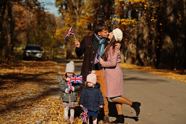 Nationalfeiertag des Vereinigten Königreichs. Familie mit britischen Flaggen im Herbstpark. Briten feiern Großbritannien. Zwei Kinder.