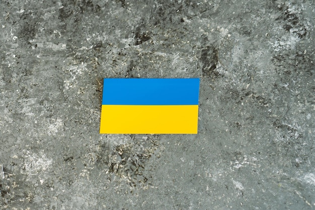 Nationalflagge der Ukraine auf grauem Betonzement-Oberflächenhintergrund Platz für Text Krieg in der Ukraine