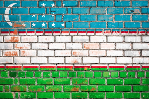 Nationalflagge Usbekistans auf einem Grunge-Backstein-Hintergrund