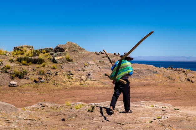 Nativo da Ilha de Taquile carregando uma sacola de tecido e troncos