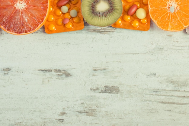Natürliche Früchte und medizinische Pillen Wahl zwischen dem Verzehr von Früchten und der Einnahme von Nahrungsergänzungsmitteln zur Stärkung der Immunität Platz für Text