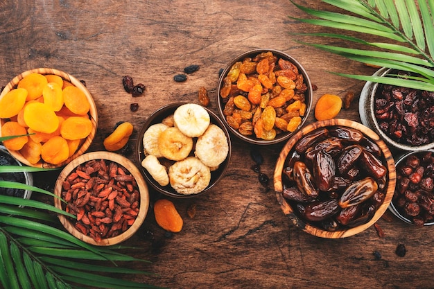 Natürliche getrocknete Früchte in Schalen Gesunder Lebensmittelsnack, sonnengetrocknete Bio-Mischung aus Aprikosen, Feigen, Rosinen, Datteln und anderen auf Holztisch