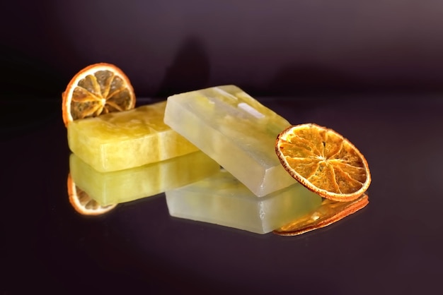 Natürliche handgemachte Zitrus-Orangen-Gelb-Öl-Bio-Seife auf dunklem Hintergrund mit trockener Orange