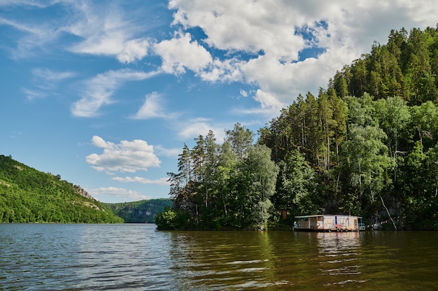 Natürlicher Blick auf grüne Felder im Vordergrund und Berge von Klippen und Hügeln an einem sonnigen Sommertag.