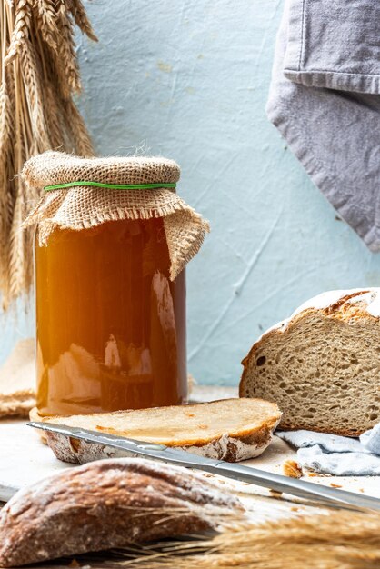 Foto natürlicher honig im glas und laib hausgemachtes brot