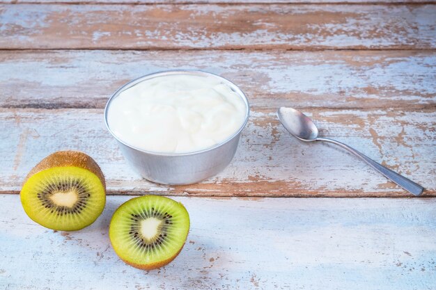 Natürlicher Joghurt und Kiwi auf Holztisch