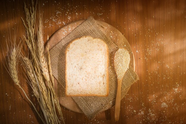 Natürlicher Kornweizen schnitt Brot auf hölzerner Tabelle mit Sonnenlicht