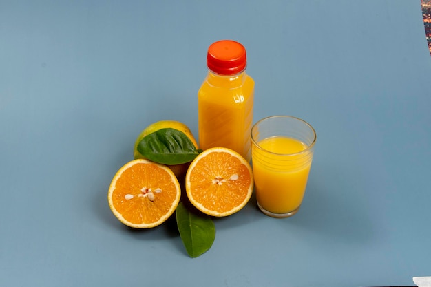 Natürlicher Orangensaft im Glas mit Flasche an der Seite