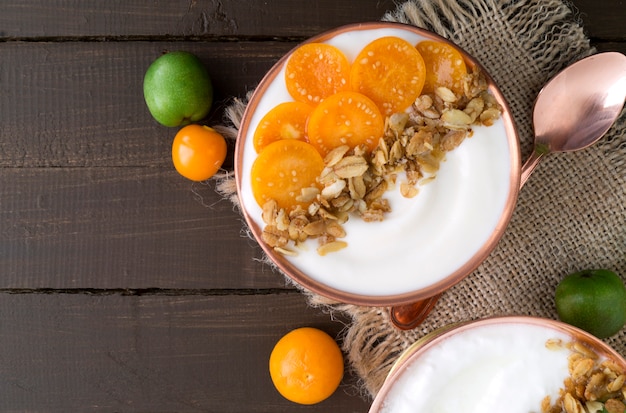 Natürlicher selbst gemachter Joghurt mit Bodenkirsche auf einem Holztisch.
