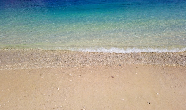 Natürlicher spritzender Wellenseesteinstrand am sonnigen Tag in Phuket-Insel.