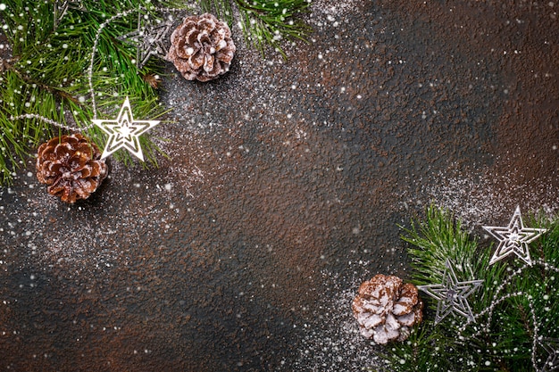 Natürlicher Weihnachtshintergrund mit Tannenzweigen, Zapfen und Schnee.