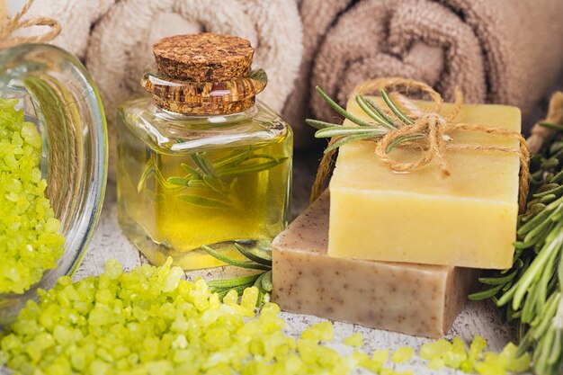 Natürliches kosmetisches Öl und natürliche handgemachte Seife mit Rosmarin auf rustikalem Holzhintergrund. Gesunde Hautpflege. SPA-Konzept.