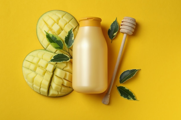 Natürliches Mango-Duschgel und Zutaten auf gelbem Hintergrund