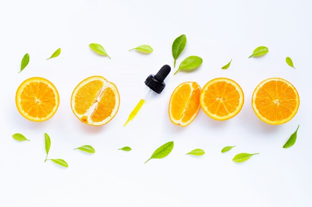 Foto natürliches orangenvitamin c des zitrusfruchtöls mit frischen orangen- und grünblättern