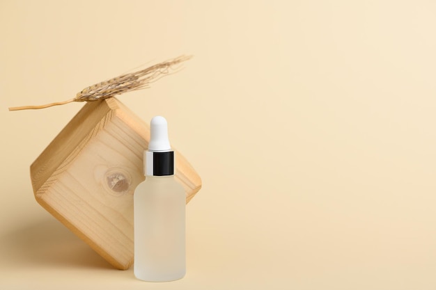 Natürliches Serum für die Gesichtspflege in einer weißen transparenten Flasche mit einer Pipette auf beigem Hintergrund. Befeuchtet die Haut mit Ölen, Vitaminen und Hyaluronsäure. Lotion zur Pflege trockener Haut.