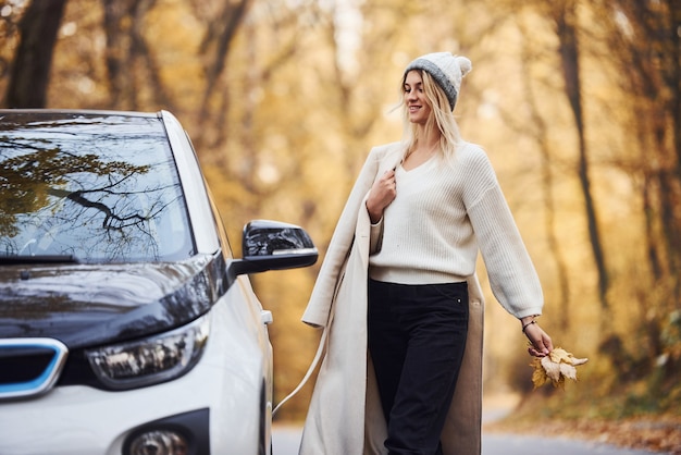 Natur genießen. mädchen haben eine herbstreise mit dem auto. modernes brandneues auto im wald.