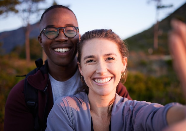 Foto natur-selfie und porträt eines interrassischen paares auf dem berg für ferien und wanderabenteuer am wochenende reise-wellness und glücklicher mann mit frau genießen ruhige freiheit und frieden bei sonnenuntergang