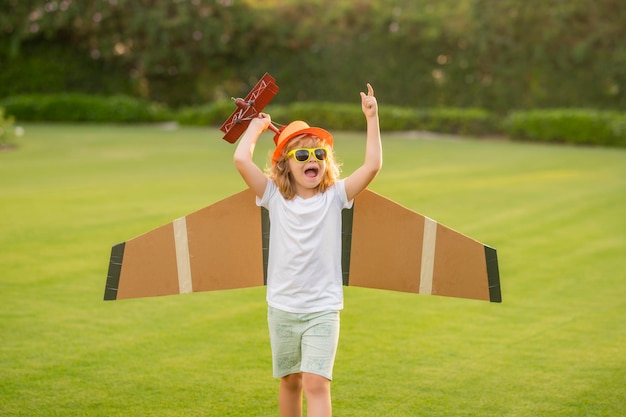 Natur- und Kinderlebensstil Traum vom Fliegen Kleine Kinder mit Spielzeugflugzeug auf einem Feld bei Sonnenuntergang Erfolgs- und Kinderführerkonzept Junge träumt davon, Pilot zu werden