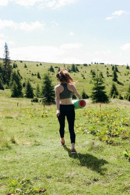 Natural, esporte, saúde, pessoas, conceito de estilo de vida - jovem e saudável praticante de ioga independente feminina, praticando meditação e poses, bela vista serena da montanha com vista para a pureza