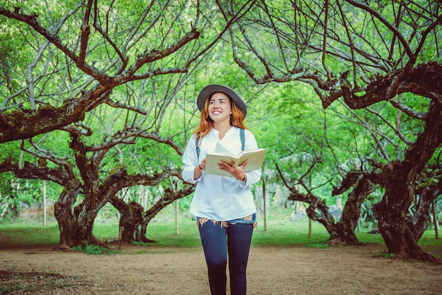 Naturaleza asiática del viaje de la mujer. Viajar relajarse. Libro de lectura en el parque. en verano.