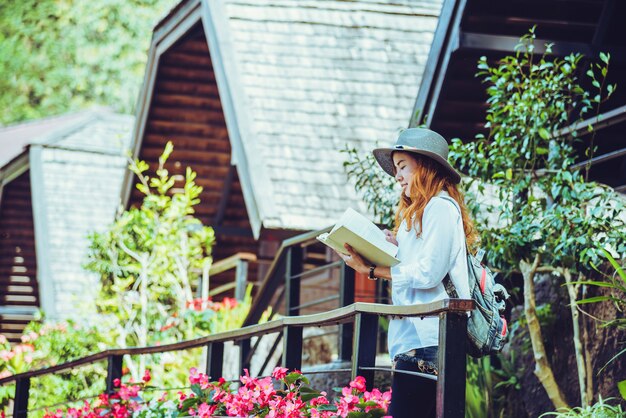 Naturaleza asiática del viaje de la mujer. Viajar relajarse. Libro de lectura de pie del balcón de la casa. en verano.