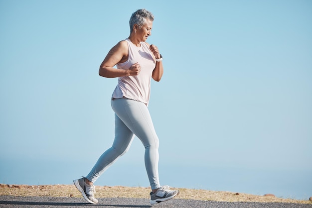Naturaleza deportiva y mujer mayor haciendo un entrenamiento de carrera para el bienestar de la salud y el ejercicio en Puerto Rico Corredora de fitness y atleta de cardio de edad avanzada en entrenamiento al aire libre para una maratón o una carrera