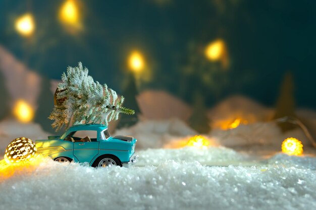 Naturaleza de invierno cubierto de nieve con un coche que lleva un árbol de Navidad