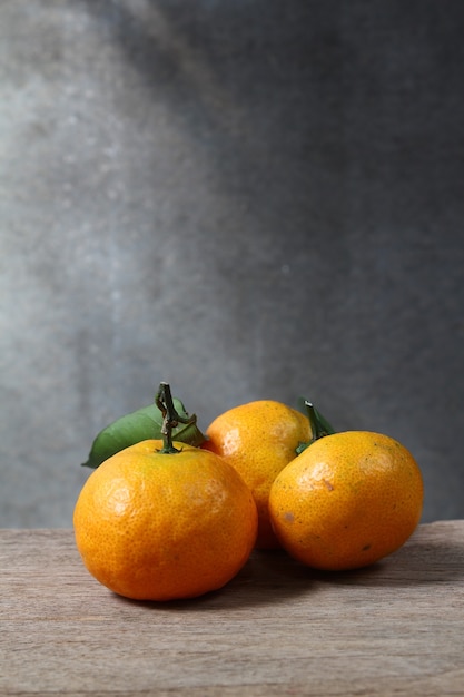 Foto naturaleza muerta con mandarinas en mesa de madera con espacio grunge