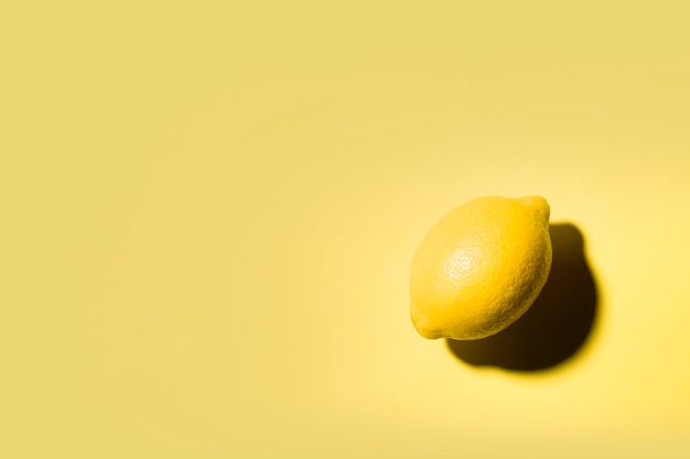 Naturaleza muerta minimalista de un limón sobre fondo amarillo