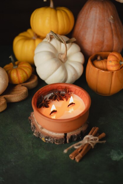 La naturaleza muerta de otoño con una vela y calabazas en la mesa