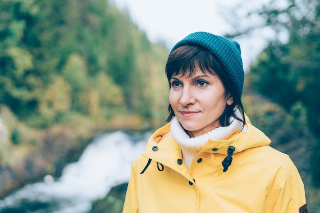 Uno con la naturaleza. Mujer mirando al bosque y cascada