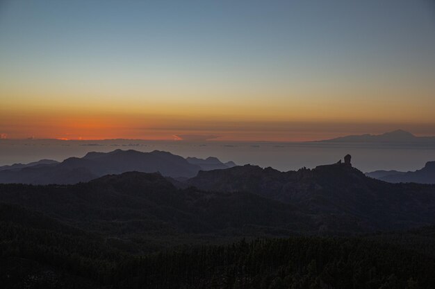 Foto naturaleza y paisaje de las montañas de gran canaria mirador roque nublo sobre la puesta de sol y vistas de tenerife