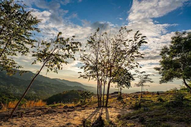 Naturaleza puesta de sol paisaje escena vista panorámica vista natural para usar en segundo plano o concepto de desarrollo ambiental y sostenible El sol cayendo sobre el cielo nublado y la tierra montañosa local